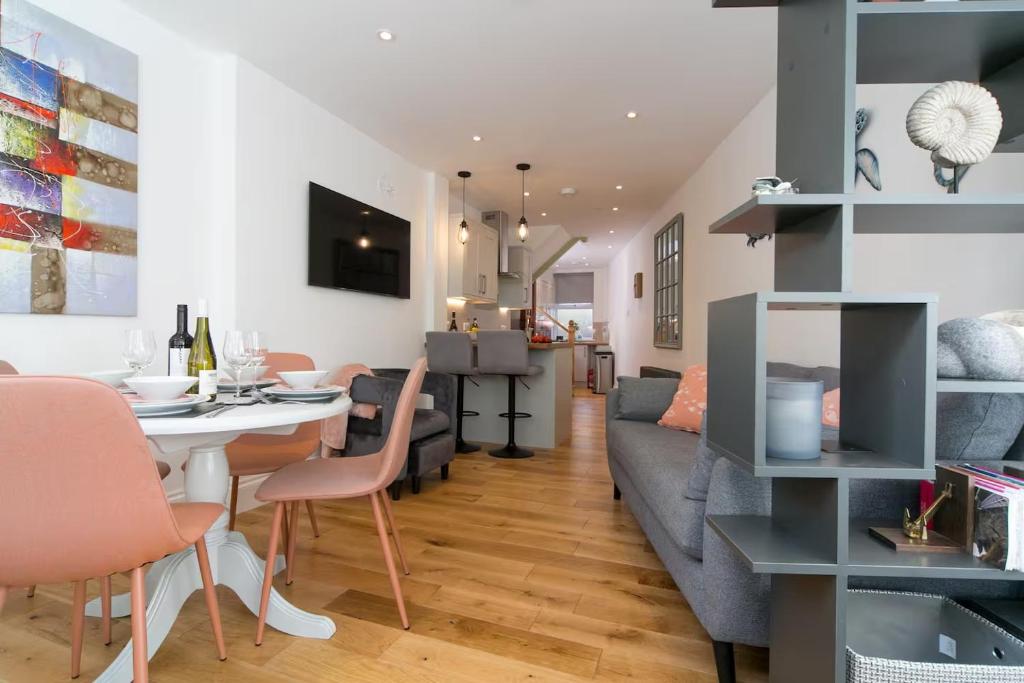 a living room and dining room with a couch and a table at Modern Town House Bangor City Centre in Bangor