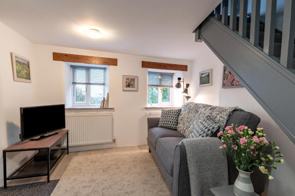 a living room with a couch and a tv at 1 Bed in Ashover oc-dclhil in Ashover