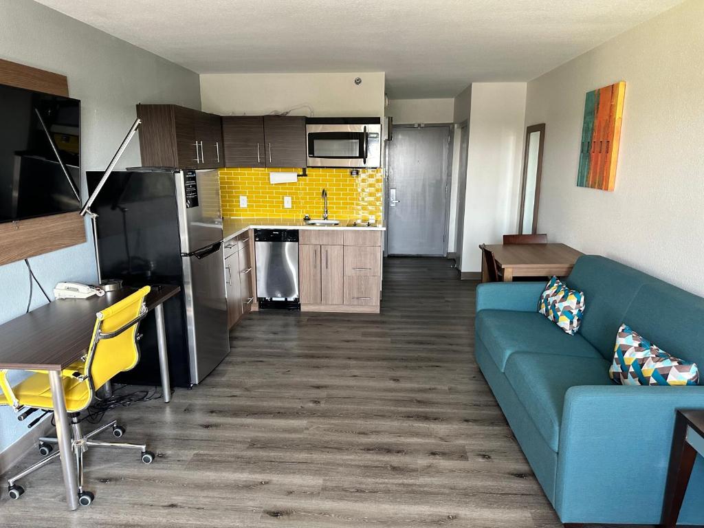 a living room with a blue couch and a kitchen at MainStay Suites Conover-Hickory in Conover