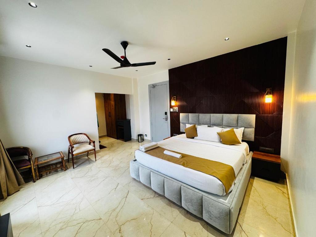 a bedroom with a large bed and a ceiling fan at Mannat Hotel in Tezpur