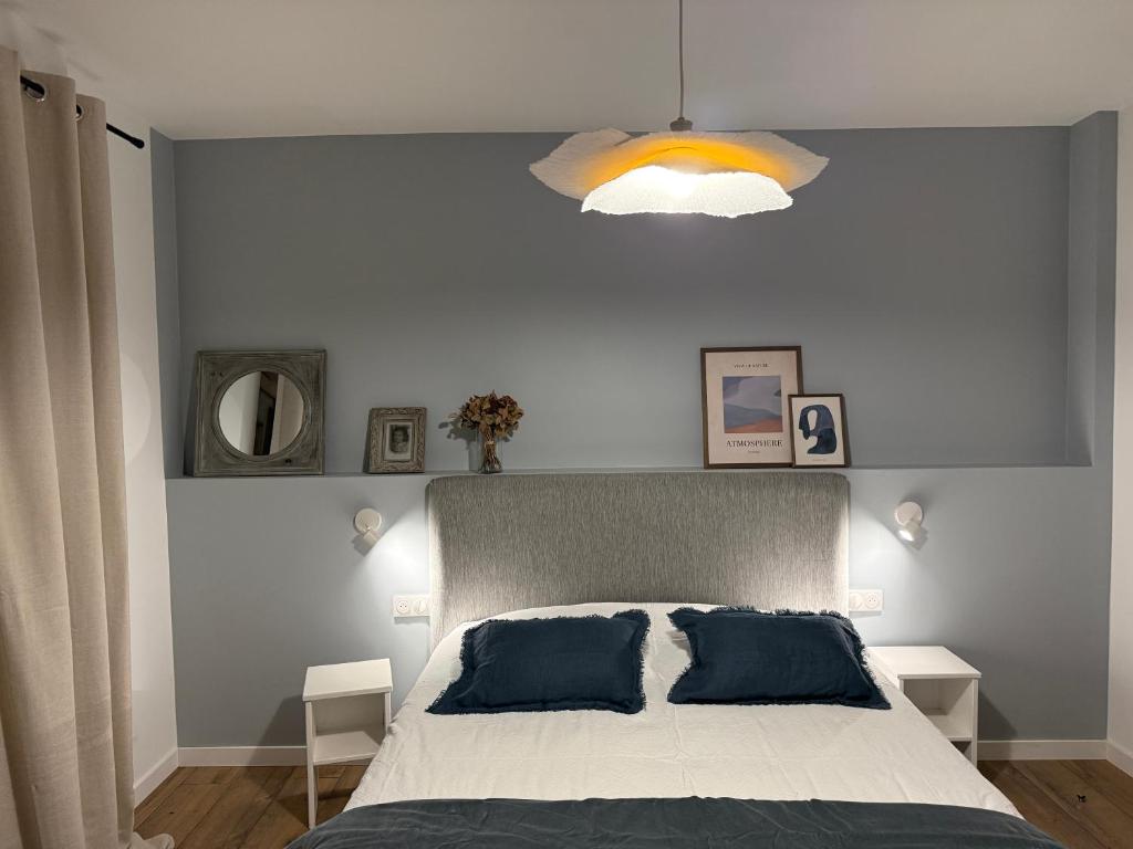 a bedroom with a large bed and a light at Chambres d'hôtes L'Ecrin des Saveurs in Schwenheim