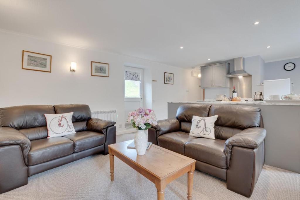 a living room with two leather couches and a coffee table at 1 Bed in Gunnerside oc-ds1016 in Gunnerside