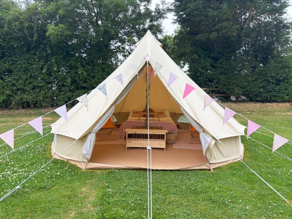 a tent with a bed in the middle of a field at Dovedale in Ashbourne