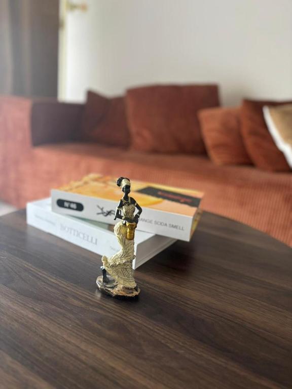 a toy figurine on a table with two books at Appartement Bissau in Dakar