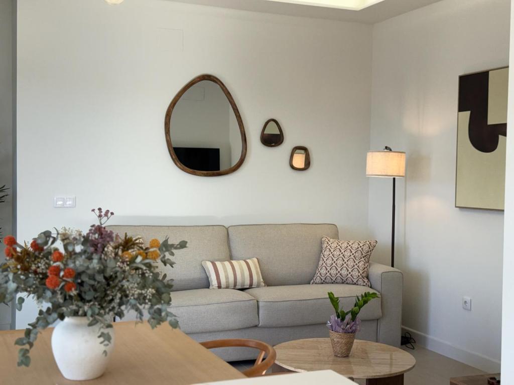 a living room with a couch and a table with a mirror at Apartamentos Las Mereras in Fuente Palmera