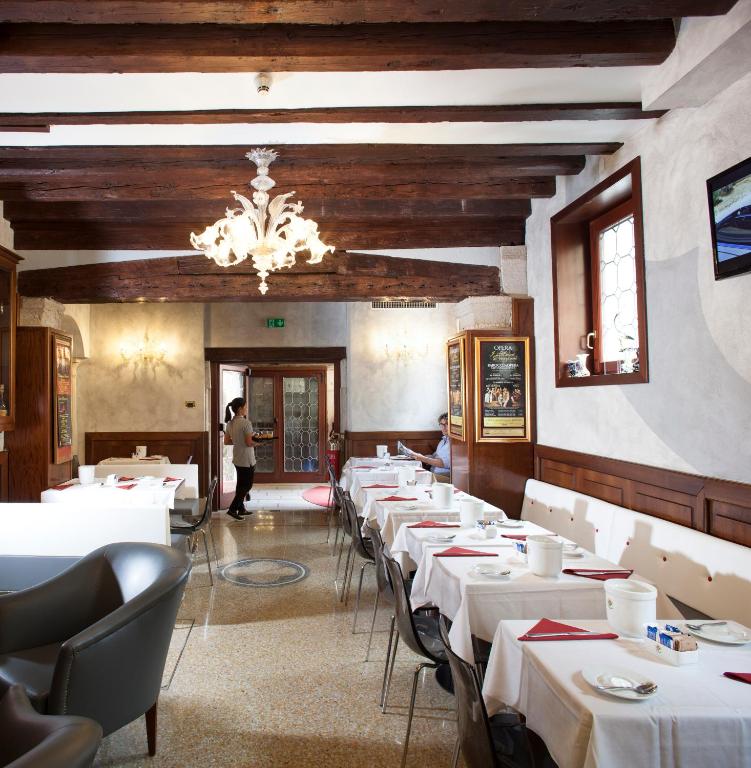 a dining room with white tables and a chandelier at Hotel Ca&#39; D&#39;Oro in Venice