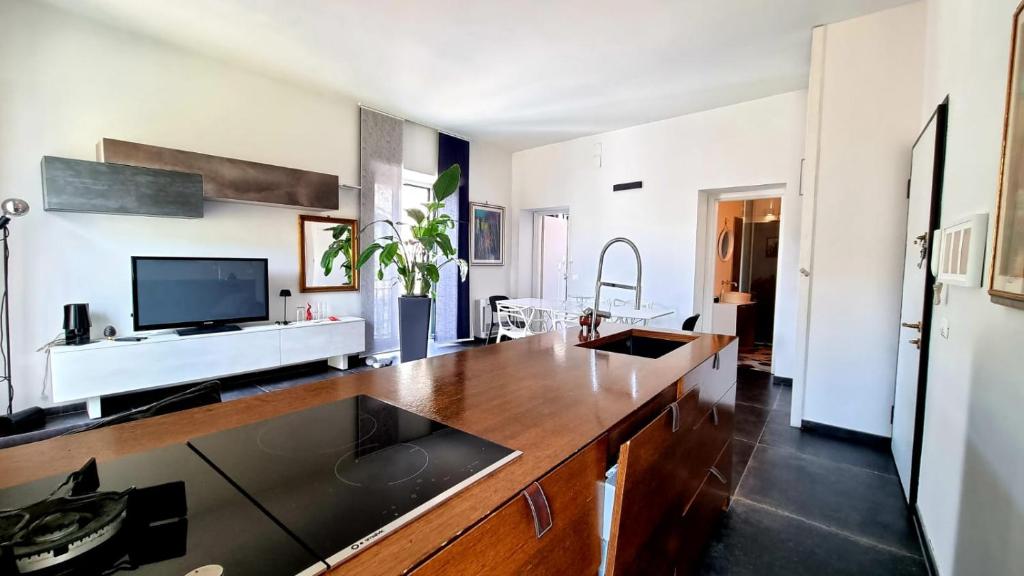 a living room with a large kitchen with a tv at Maison Grimoaldo10 in Salerno