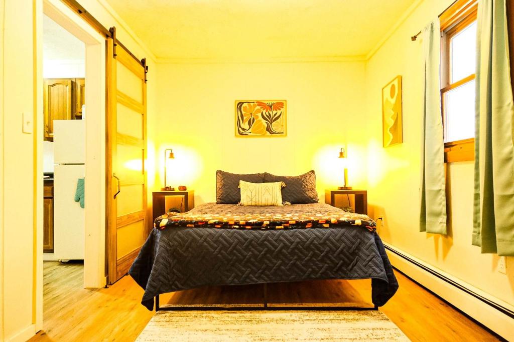 a bedroom with a bed and two lamps and a door at Elevated Ski Chalet at Powderhorn Mountain in Bessemer
