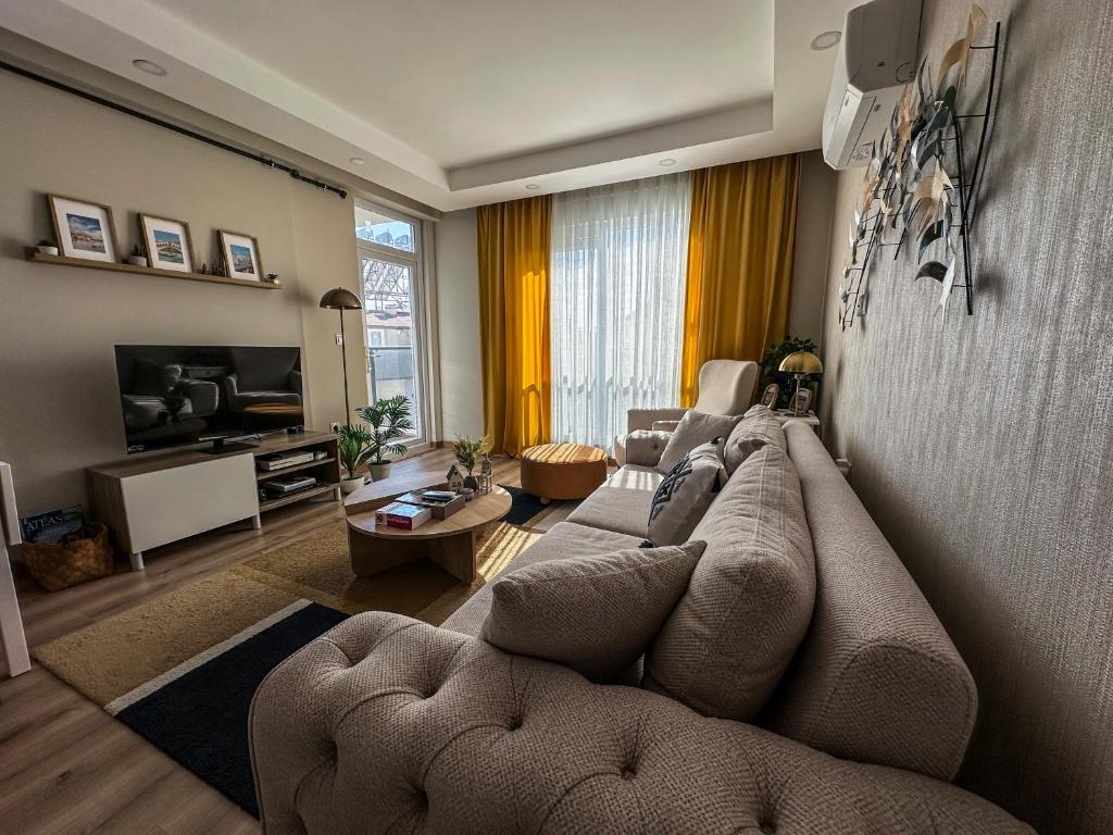 a living room with a couch and a tv at Chic 2BR City Center Flat in Antalya