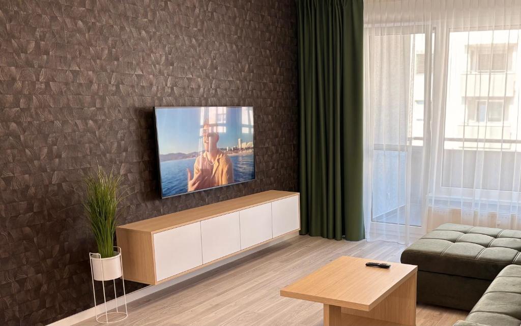 a living room with a flat screen tv on a brick wall at home&stay - free parking in Trenčín