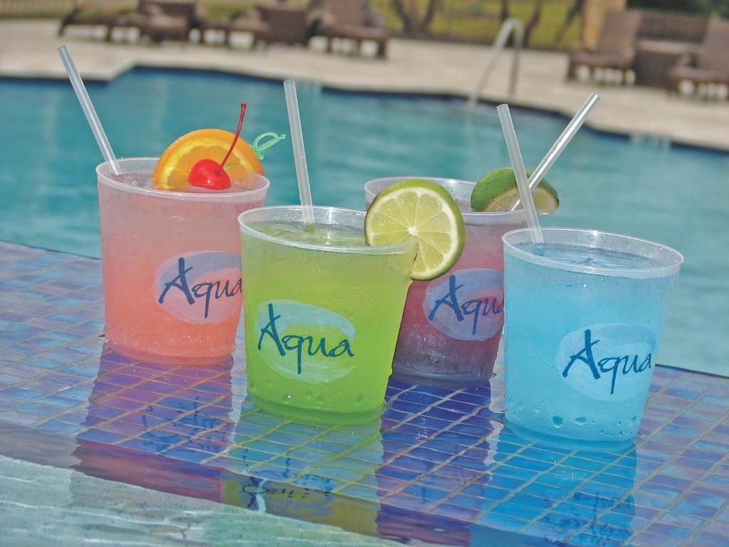 drei Getränke auf einem Tisch neben einem Pool in der Unterkunft Treasure Bay Casino &amp; Hotel-Adults Age 21 and Above in Biloxi