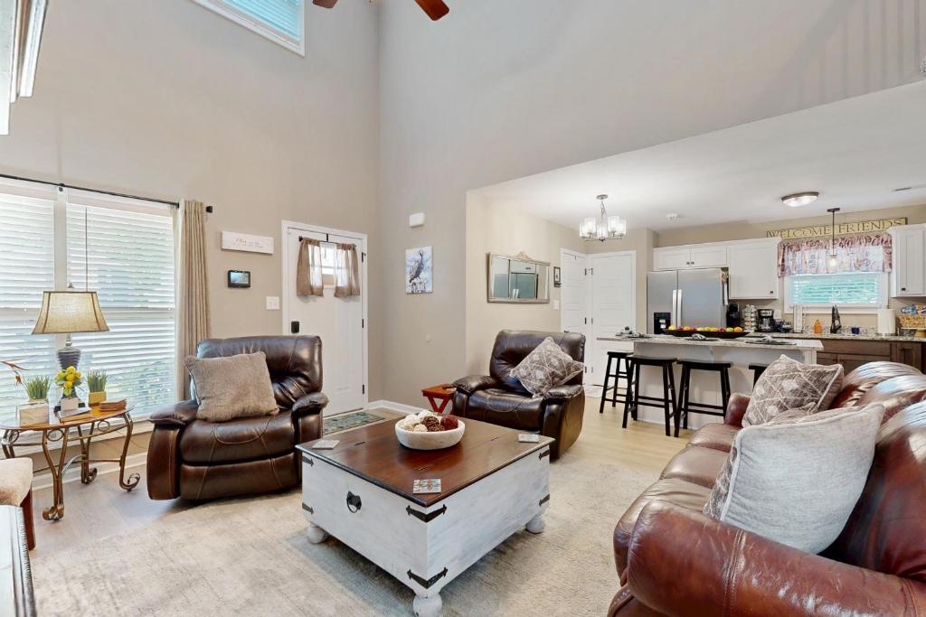 a living room with leather furniture and a kitchen at Gateway to Fort Campbell! Home w/ Furnished Deck in Clarksville