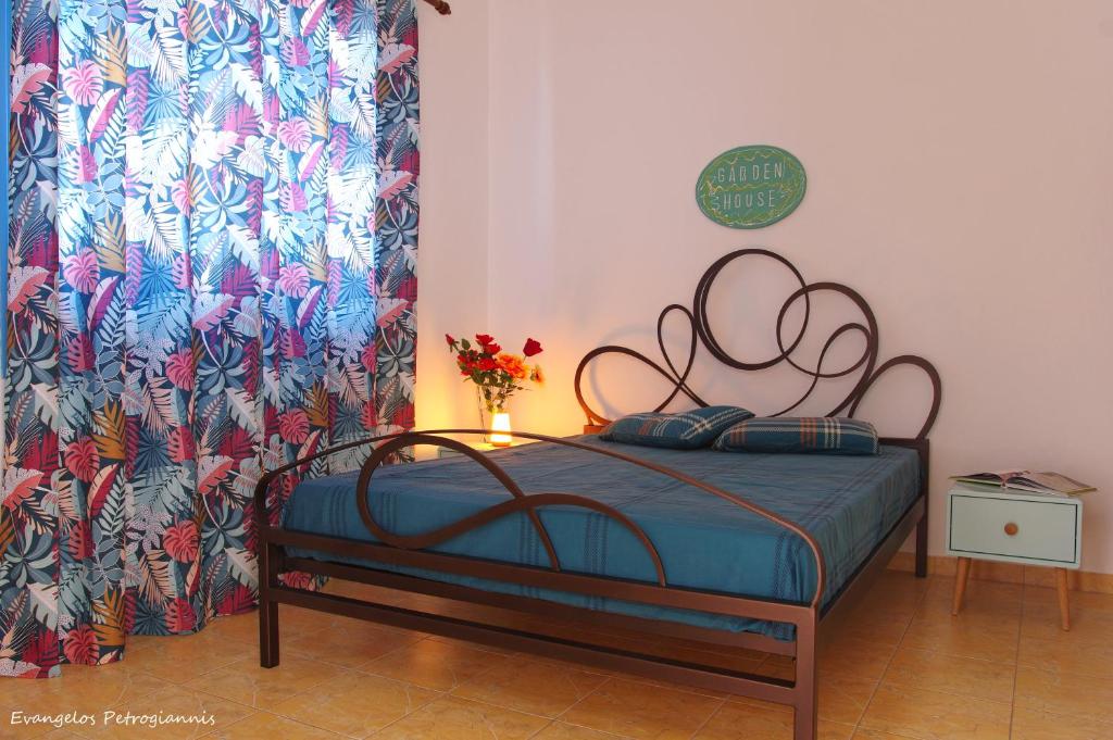 a bedroom with a bed with a flowered curtain at Garden house in Amarynthos