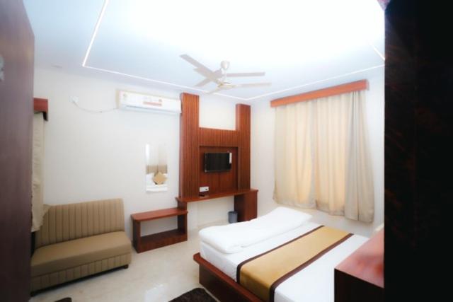 a hotel room with two beds and a couch at The Gripa Hotels in Chitrakoot