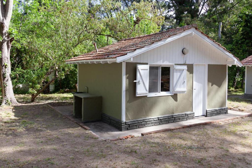 a small green house with a window in a yard at Bungalow Caravan in Villa Gesell