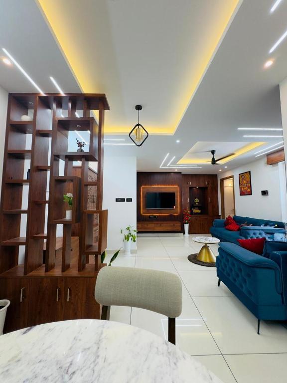 a living room with a blue couch and a tv at Haven by Glass Loft-Premium 2BHK near KIMS and GG Hospital in Trivandrum