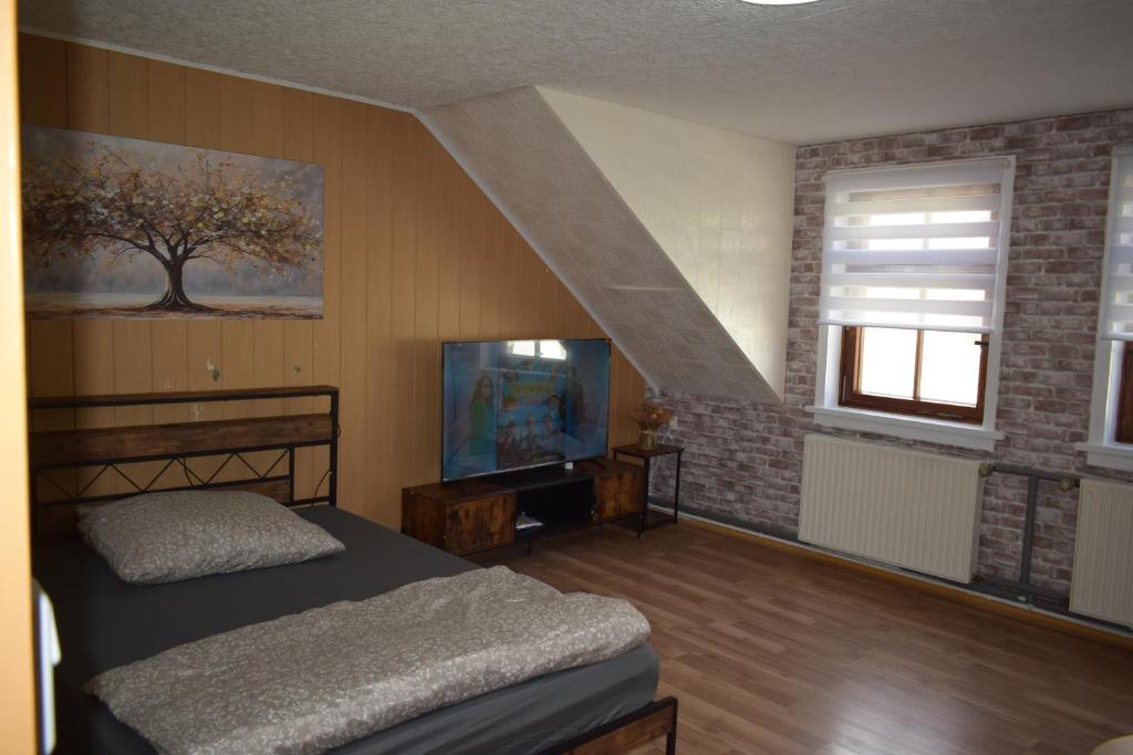 a bedroom with a bed and a tv and a staircase at Ferienwohnug Home in Gotha