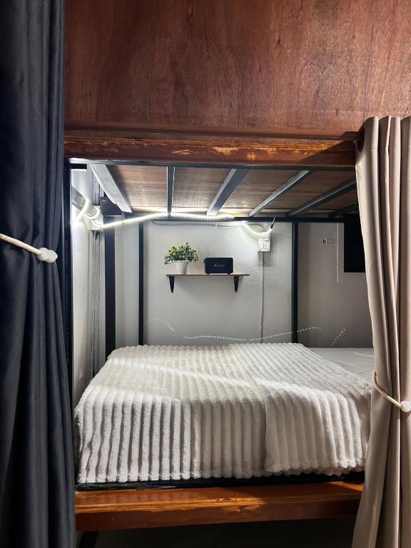 a bunk bed with a white bedspread on it at Blueka Hostel Ko Chang in Khlaung Phai Bae