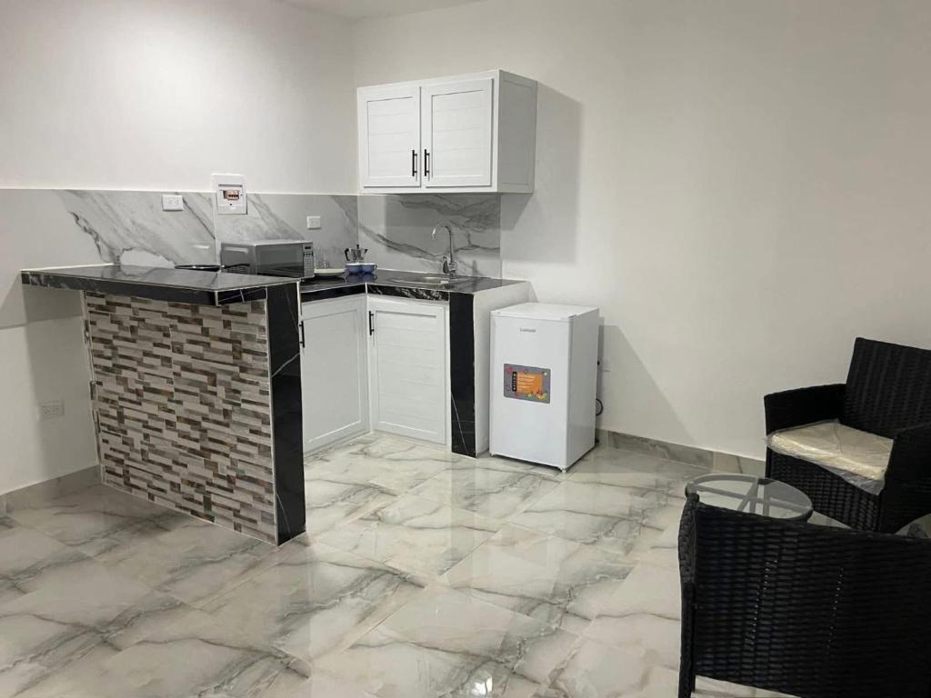 a kitchen with white cabinets and a brick wall at Brisas del mar in Santa Cruz de Barahona