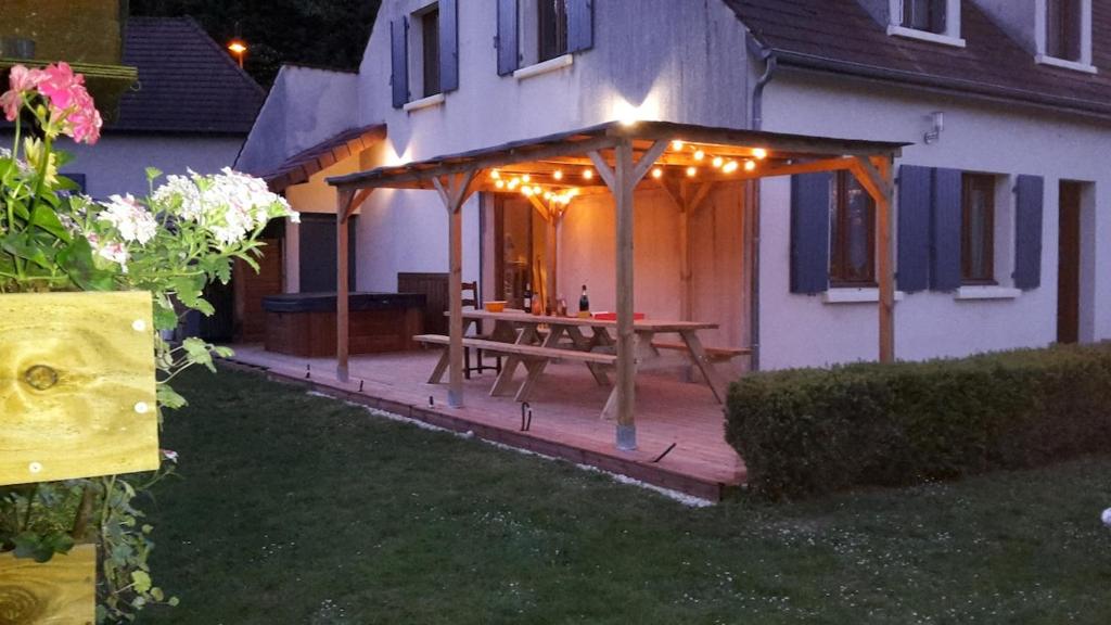 a wooden deck with a picnic table in front of a house at Le petit Flotteur in Chevroches