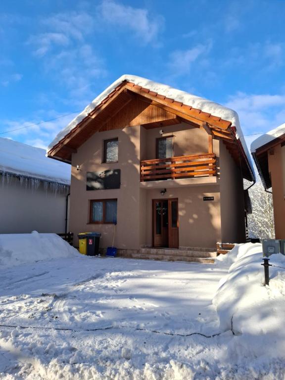 a house with snow on the ground at Casa Iris Mogoșa in Baia-Sprie