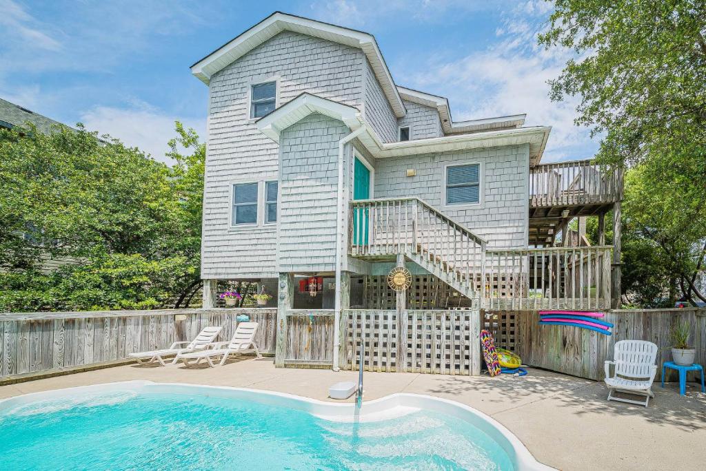 a house with a deck and a swimming pool at Beach Place - Corolla, Ocean Sands, 370 Yards to the Beach, Flex Stays, Pets OK, Pool! in Corolla