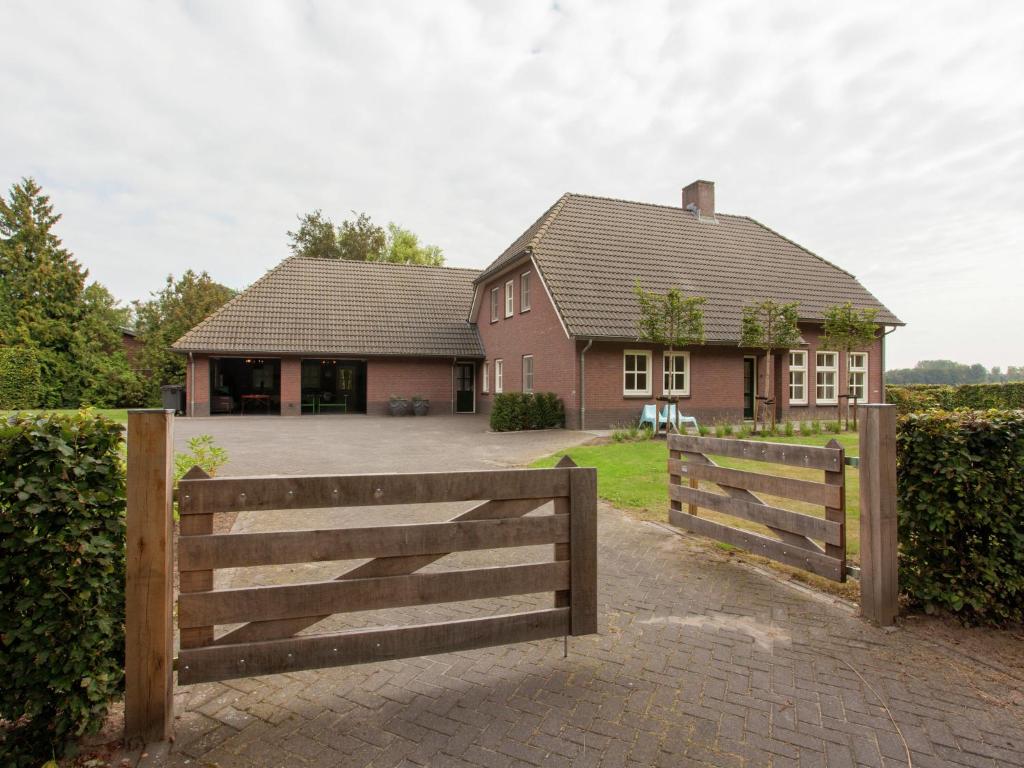 uma casa com uma cerca de madeira e uma entrada em Luxurious holiday home in the middle of the Leenderbos nature reserve, near quiet Leende em Leende