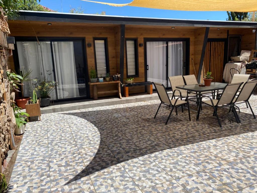 a patio with a table and chairs and a house at Punta Luna in La Serena