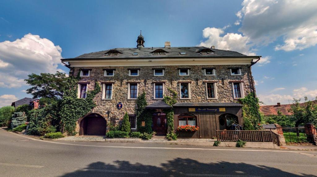 a large stone building on the side of a street at Apartmány v Buši in Buš