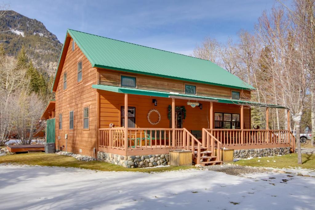 a log cabin with a green roof in the snow at Boulder Dreams! Mtn-View Gem in McLeod in McLeod