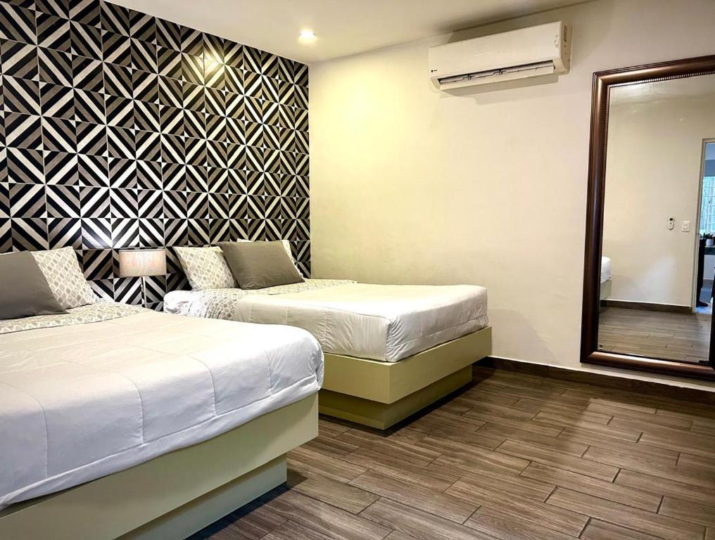 a hotel room with two beds and a mirror at LÁZARO D primer piso in Monterrey