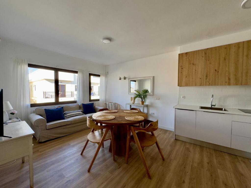 a kitchen and a living room with a table in a room at Bel Air Surf Escape in El Cotillo