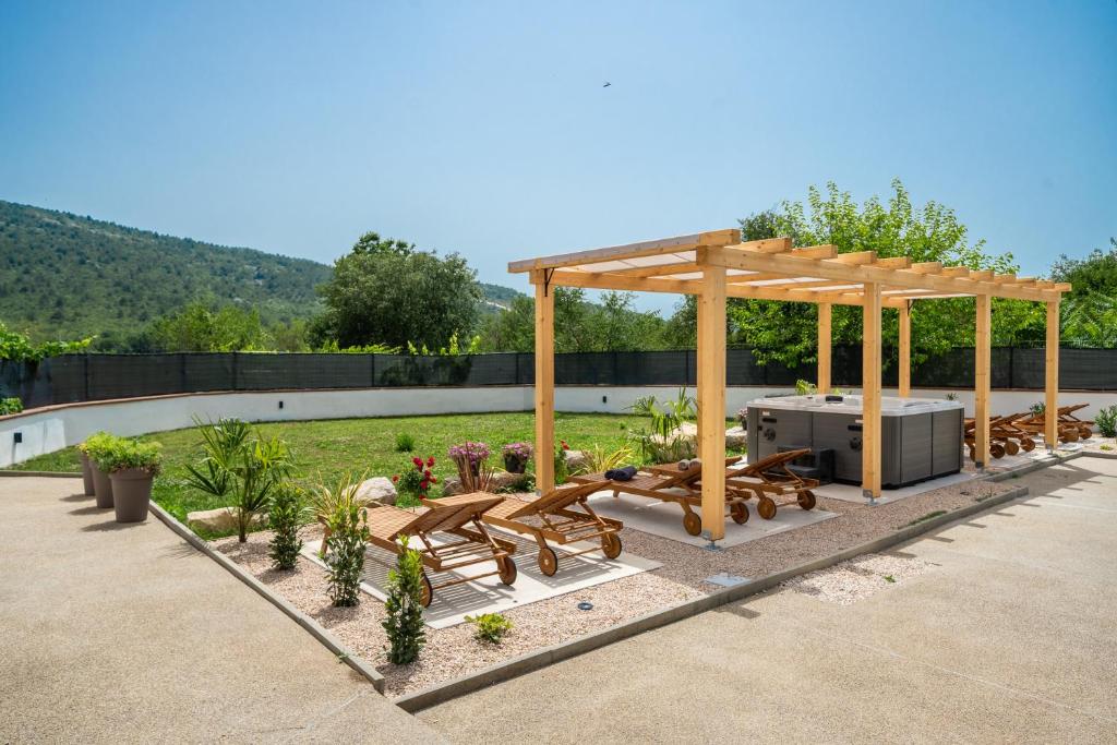 a gazebo with a picnic table and benches at Holiday house with heated pool in Neorić