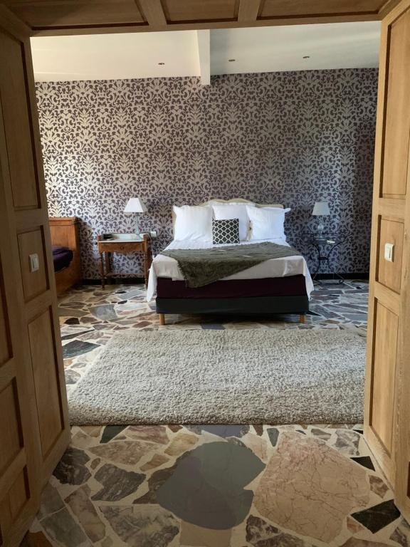 a bedroom with a bed and a patterned wall at Le Jardin de LaCoste in Narbonne