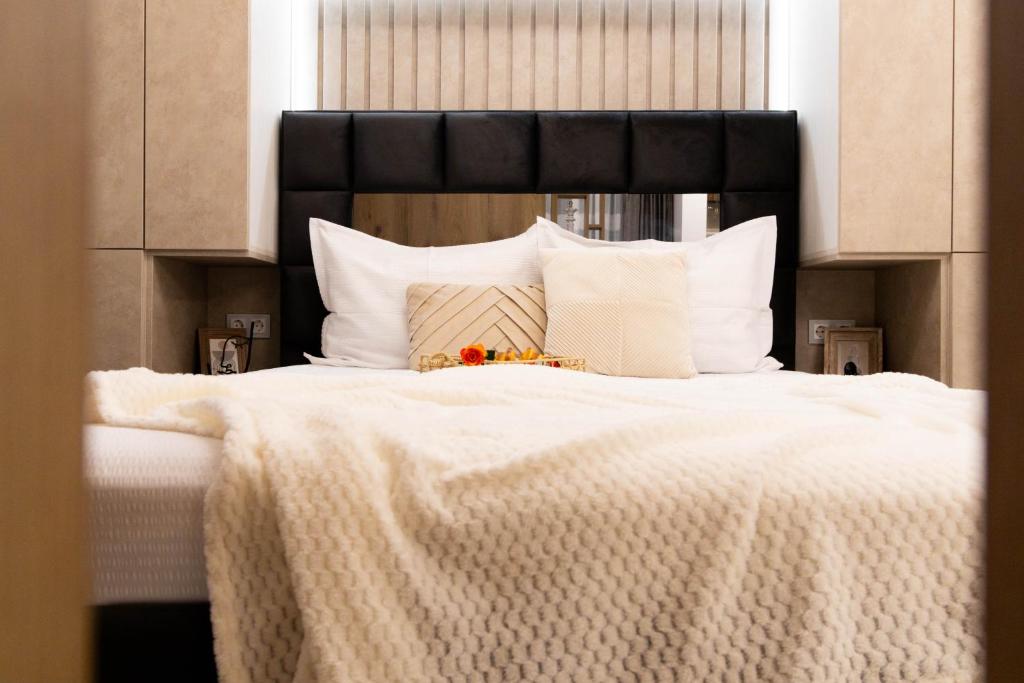 a large white bed with a black headboard and white pillows at Atelier AS in Voluntari