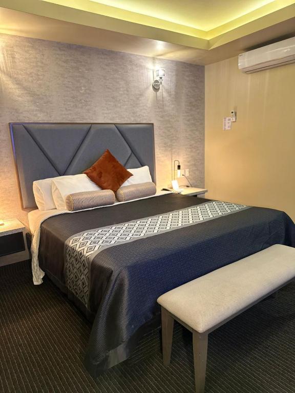 a bedroom with a large bed with a blue headboard at Hotel Boutique Querencia in Tijuana