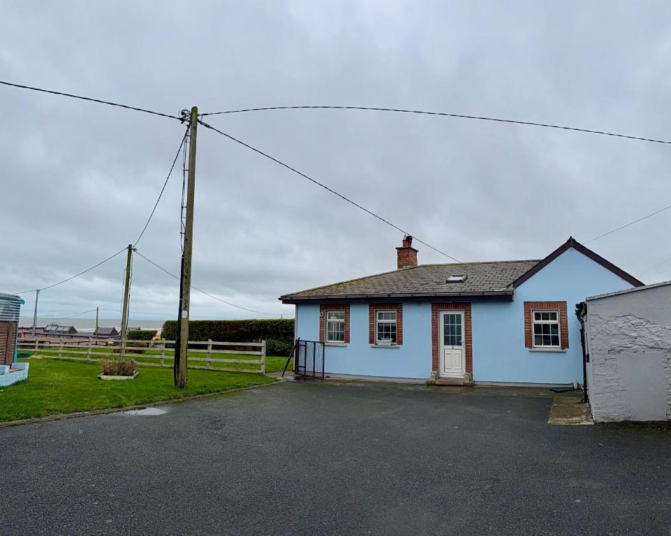 a small blue house with a pole in front of it at Beachfront Cottage - 3 bedrooms in Clogherhead