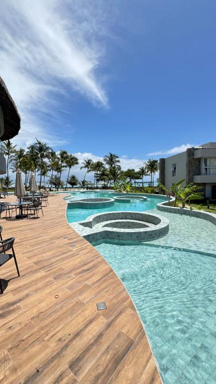 a large swimming pool with a wooden deck at Casa Marimar Milagres- Praia do Marceneiro in Passo de Camarajibe
