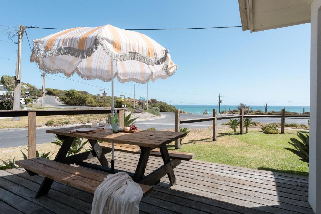a picnic table with an umbrella on a deck at The Nook in Aldinga Beach