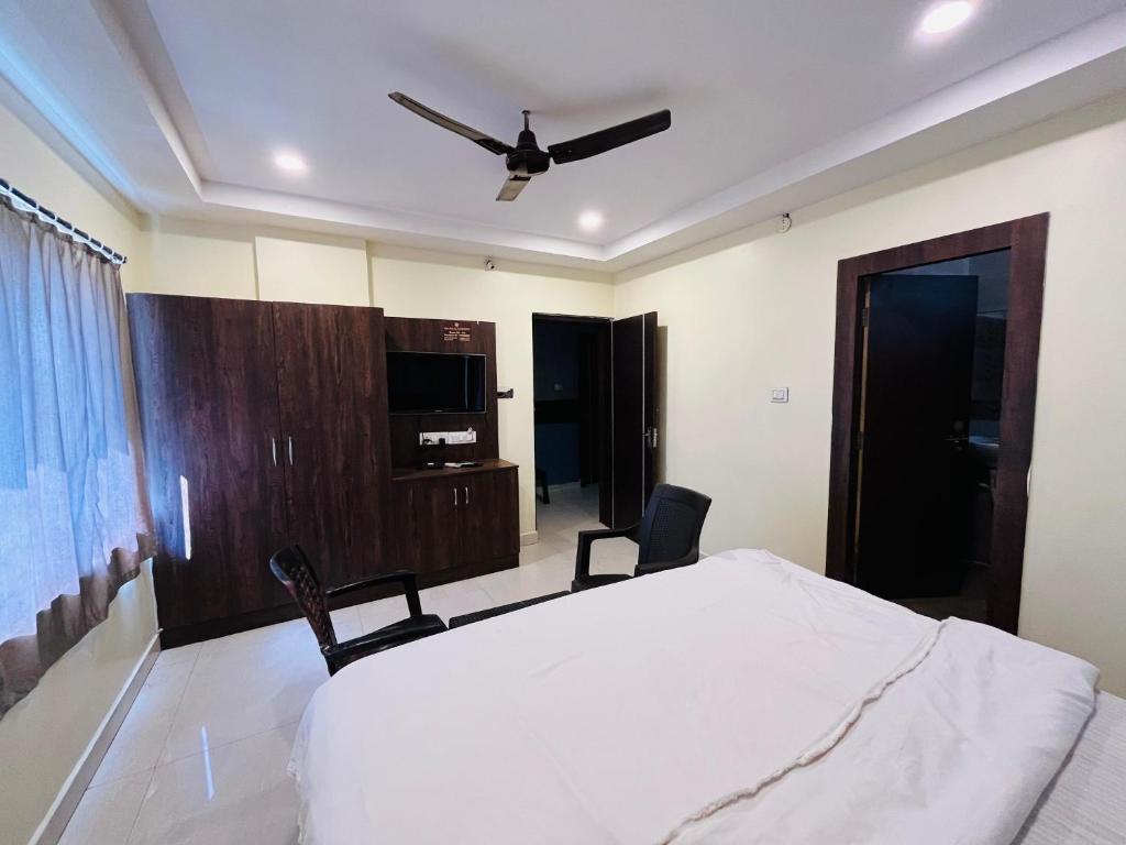 a bedroom with a bed and a ceiling fan at The Royal Comforts in Visakhapatnam