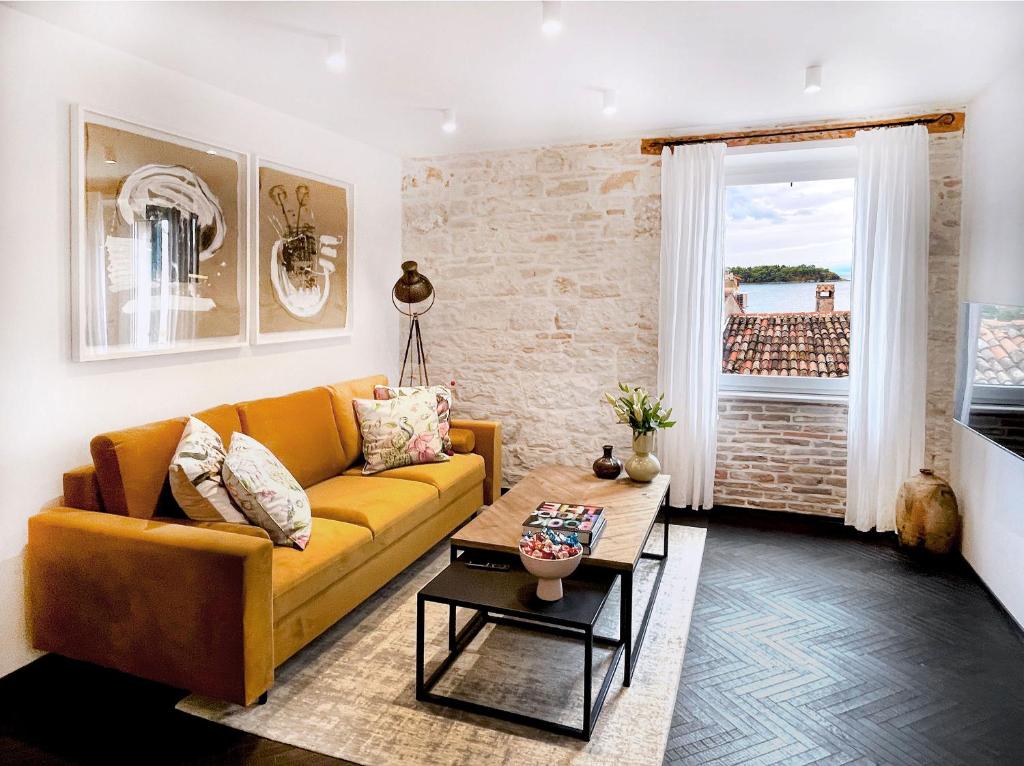a living room with a yellow couch and a table at Golden View - Old town apartment in Rovinj