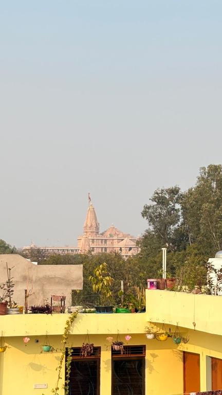 a yellow building with a building in the background at Shree Rameshth Homestay in Ayodhya