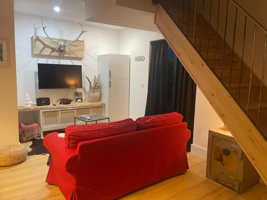 a living room with a red couch and a tv at Cosy nap under the Paps in Killarney