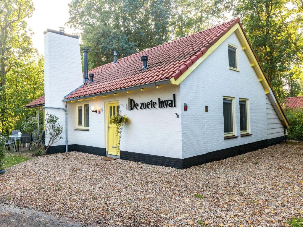 una pequeña casa blanca con puerta amarilla en Charming Holiday Home in Koudekerke Dishoek, en Dishoek