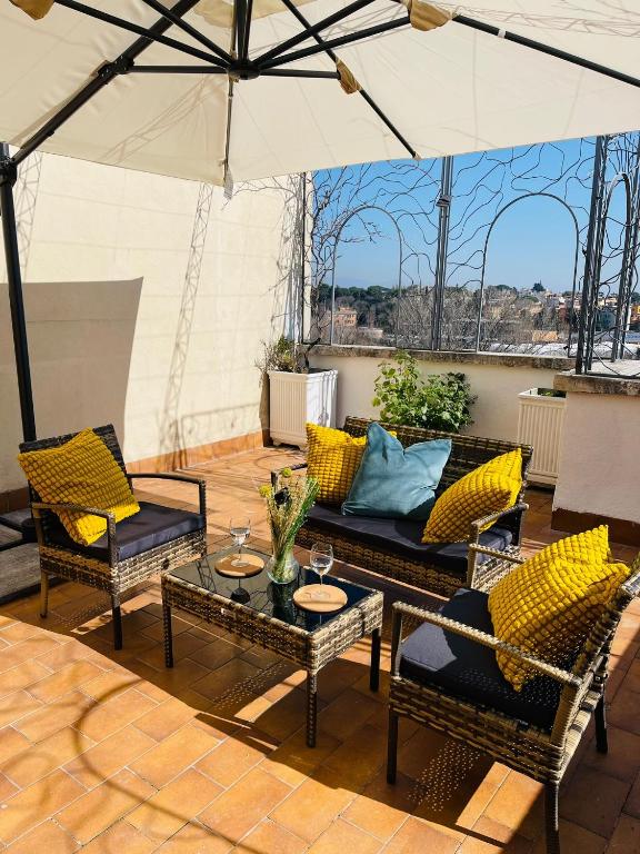a patio with a couch and chairs and an umbrella at Bencivenga Terrace in Rome