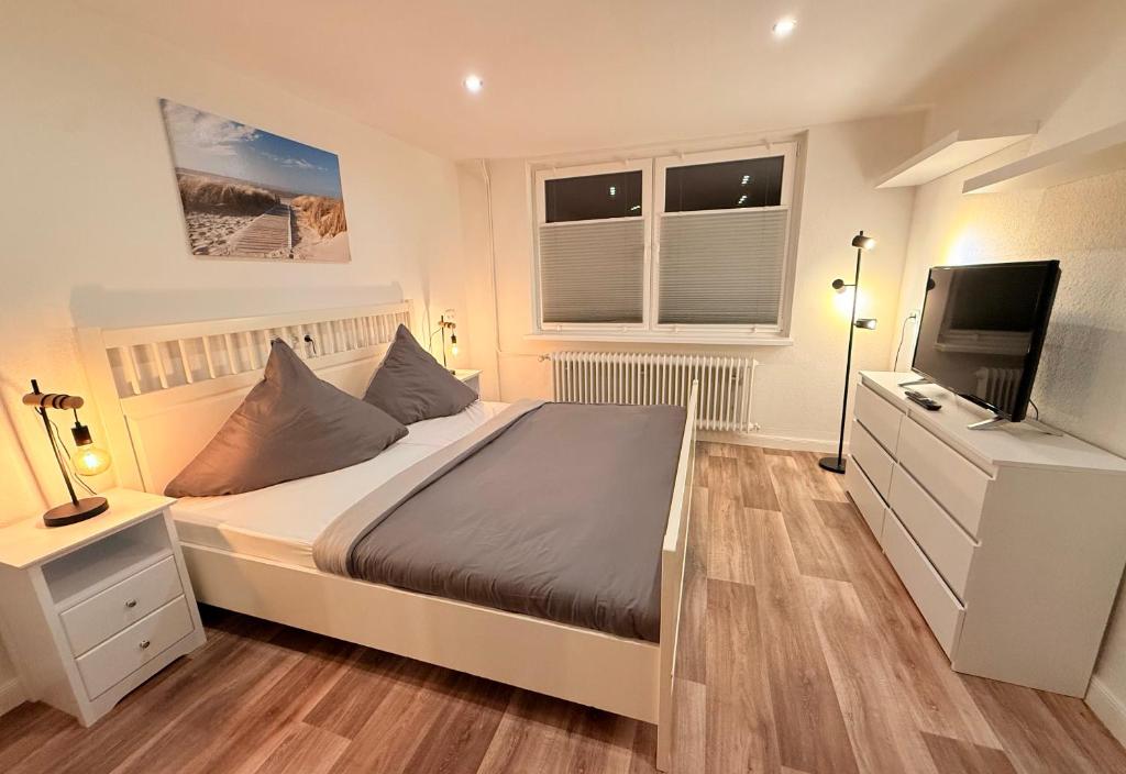 a bedroom with a bed and a flat screen tv at Ferienhaus Teenös in Hinte