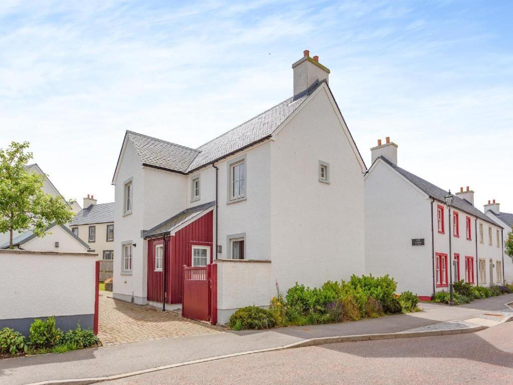 a row of houses with red doors on a street at One The Loan in Inverness