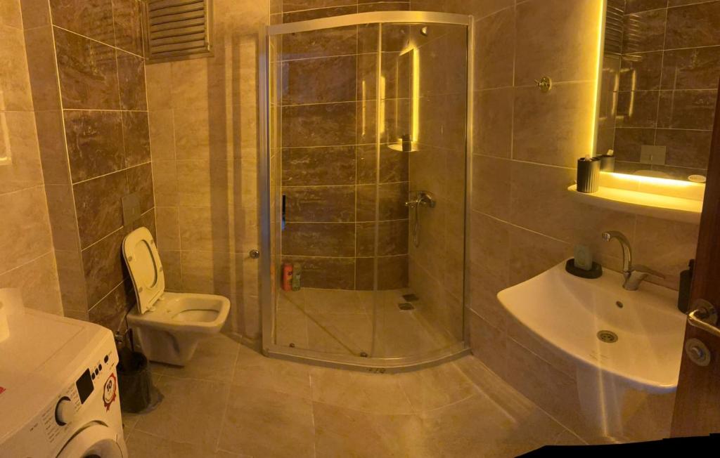 a bathroom with a shower and a toilet and a sink at Roz Family Mansion 2 in Diyarbakır