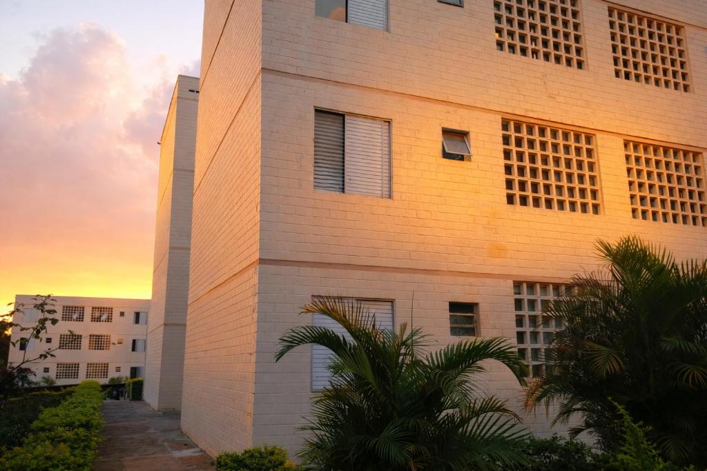 a building with the sunset in the background at KOKIRA Apê in Campinas