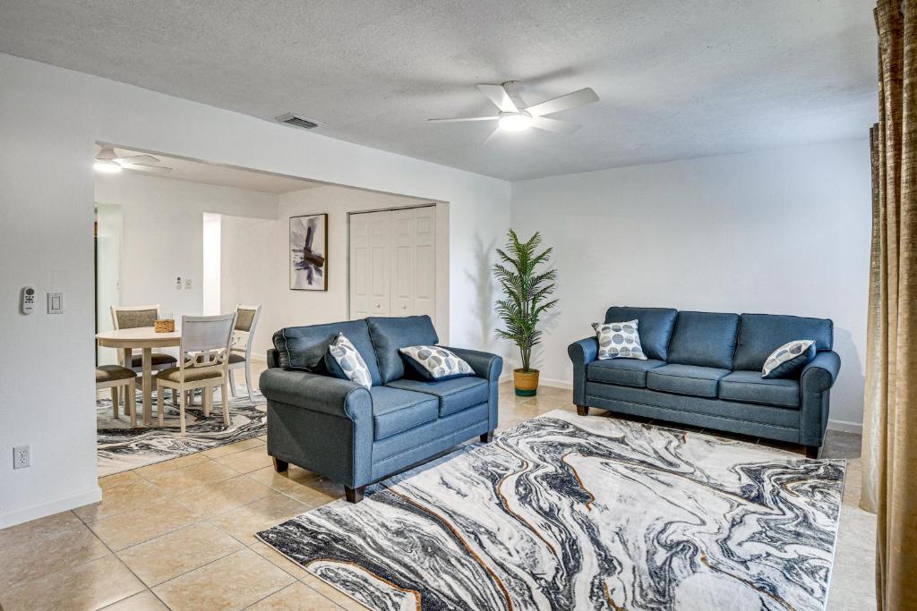 a living room with two blue couches and a rug at Sun, Sand & Poolside Relaxation! Ormond Beach Unit in Ormond Beach